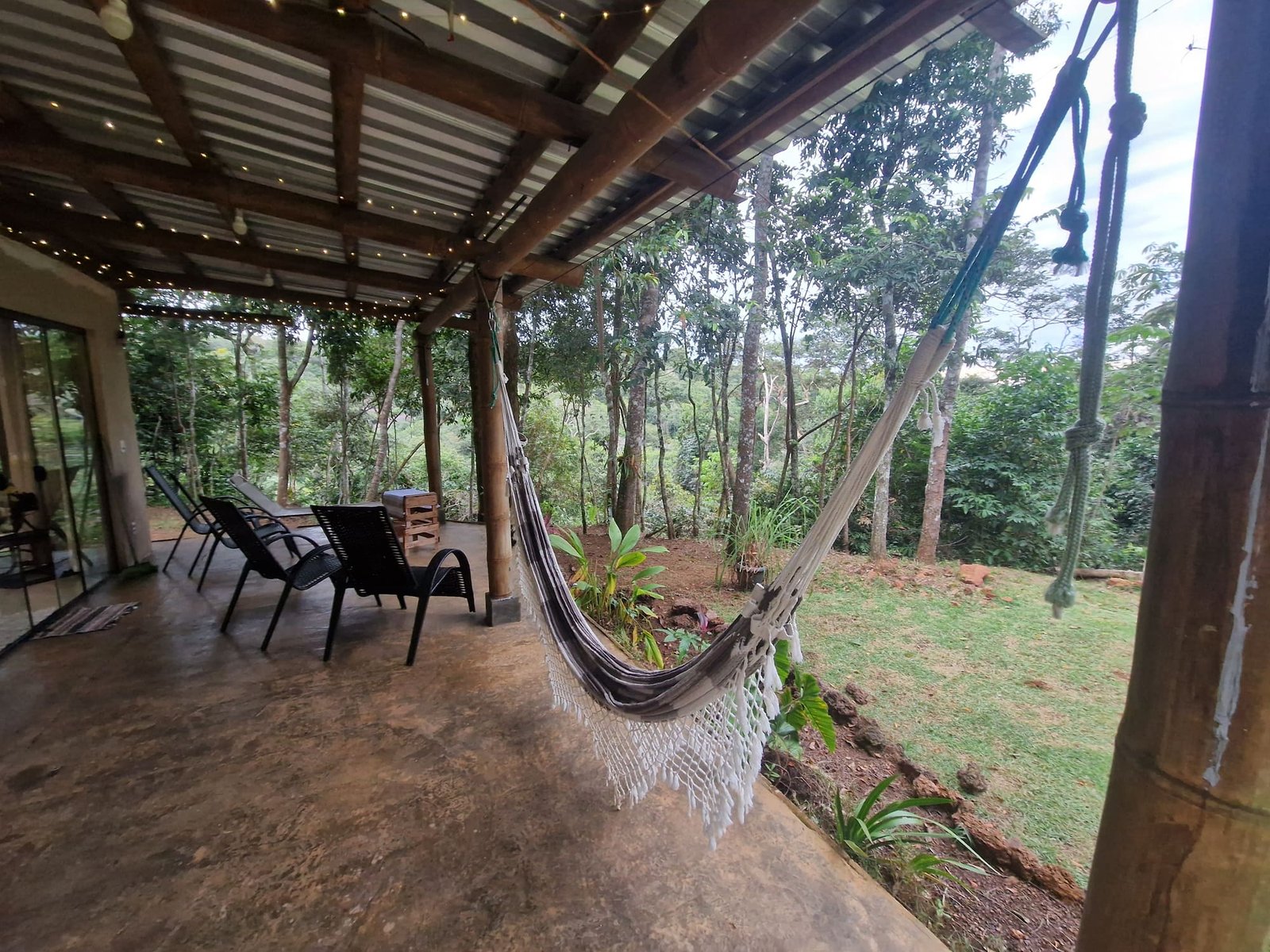 Veranda da Casa Bambu com rede e vista para a mata